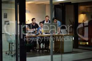 Late nights at the office. Shot of employees working in an office at night.