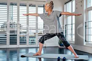 Keep your legs steady. Shot of a relaxed mature woman practicing yoga inside of a studio during the day.