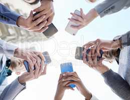 Connecting faster for the best way forward. Shot of a group of unrecognisable businesspeople using their cellphones together at and outside meeting.