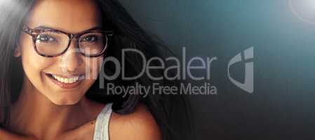 The smile that melts hearts. Studio portrait of an attractive young woman wearing glasses.