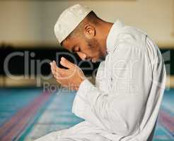 Faith can move mountains. Shot of a young muslim male praying in a mosque.