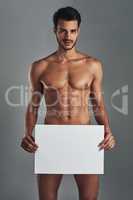 Signage for those sensitive topics. Studio shot of a handsome and muscular young man holding a blank sign against a grey background.