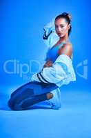 Fitness is my religion. Full length portrait of an attractive young female athlete posing on her knees against a blue background.