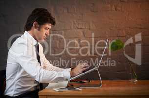 Nothing makes a person more productive than the last minute. Shot of a businessman working on his laptop after hours.