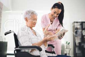 Dont shrink to fit in child, let them choke. Shot of a young nurse sharing information from her digital tablet with an older woman in a wheelchair.