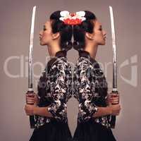 Shes a warrior. Mirrored studio shot of an attractive young woman holding a samurai sword.