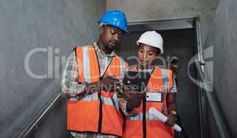 The construction crew doing what they were born to do. Shot of a young man and woman using a digital tablet while working at a construction site.