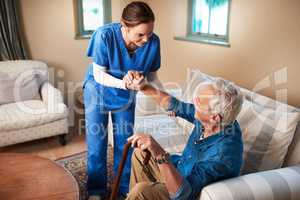 Her caring nature makes her the perfect caregiver. Shot of a caregiver assisting her senior patient at home.