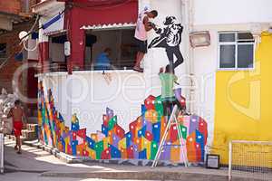 Urban artists. Shot of two young graffiti artists painting a design on a wall.