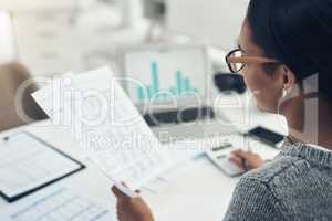 Busy with her tax return filing. Closeup shot of an unrecognisable businesswoman calculating finances in an office.