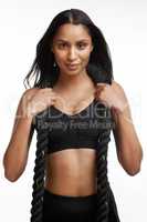 Do it for crop tops and jaw drops. Studio portrait of a sporty young woman posing with battle ropes around her neck against a white background.