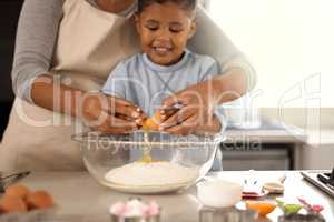 A lesson in tenderness. Cropped shot of an adorable little boy baking with his mom at home.