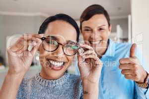 Better vision, better life. Shot of an optometrist giving thumbs after after an eye exam with a patient.