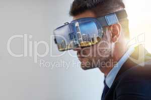 Envisioning his empire. Shot of a businessman wearing a VR headset while working in his office.