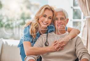 Together well make these years beautiful. Shot of a young nursing home nurse hugging her male elderly patient.