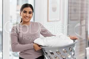 Laundry is actually infinite. Shot of a beautiful young woman doing the laundry at home.