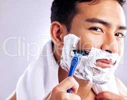 Its time to get that baby face back. Cropped shot of a handsome young man shaving his facial hair.