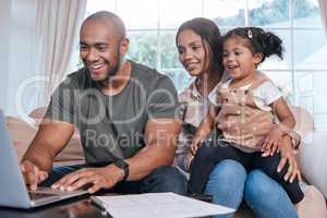 Its never to early to start investing for her future. Shot of a couple and their little daughter using a laptop at home.