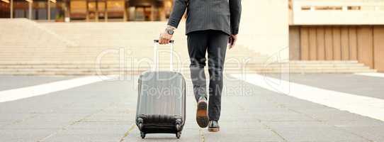 Making my way downtown. Shot of a businessman walking around town with his luggage.