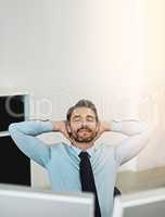 Taking a moment to mellow out. Shot of a mature businessman relaxing at his work desk.