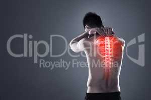 Dont take risks with a back injury. Rearview shot of a young man in the studio with cgi highlighting his back injury.