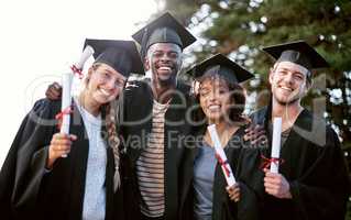 Anything is possible through hard work. Portrait of a group of students standing together on graduation day.