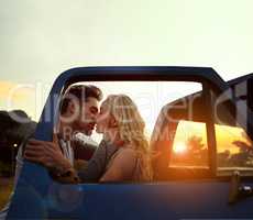 Time stands still with every kiss. Shot of an affectionate young couple enjoying a roadtrip together.