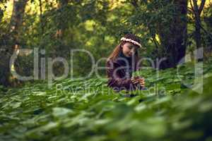 She believes in nurturing nature. Shot of a little girl playing outdoors in a forest.