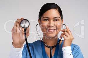 Trade in your heart for a better one. Portrait of a young doctor using a stethoscope against a white background.