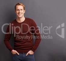 He has a relaxed outlook. Portrait of a handsome young man in a studio in front of a gray background.