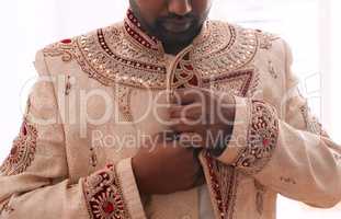 The grooms style is on point. Cropped shot of an unrecognizable bridegroom fastening his attire while getting dressed on his wedding day.