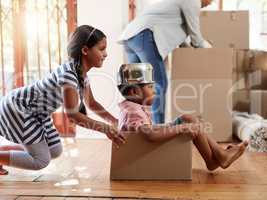Theyre already filling their new home with tons of fun. Shot of two little siblings playing with a cardboard box while moving house.