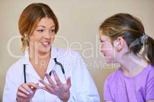 Explaining in a way her young patient can understand. Shot of a pediatrician examining a little girl in her office.