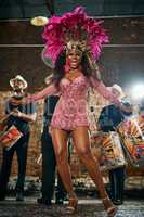 Allow the beat to be your guide. Full length portrait of a beautiful samba dancer performing in a carnival with her band.