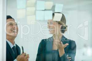 Theyre highly driven to compete and win. Shot of coworkers using sticky notes against the wall during a brainstorming session.