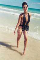 Nothing is better than a good day at the beach. Shot of a beautiful young woman in her bathing suit at the beach.