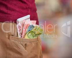 Dont be careless with your money. Cropped closeup shot of a man with Thai baht sticking out of his back pocket.