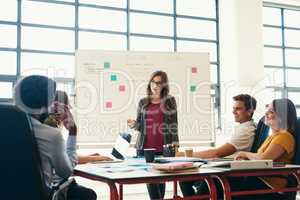 We are here to create and contribute. Shot of creative employees having a meeting in a modern office.