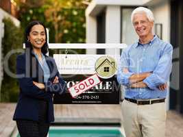 Cropped portrait of an attractive young real estate agent and her male client standing with their arms crossed next to a sold sign outside of his newly purchased home