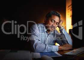 The long hours have worn him out. Shot of a mature businessman sleeping at his desk while working late in an office.