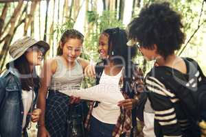 Life's good in the great outdoors. Shot of a group of teenagers looking at a map while exploring nature together at summer camp.