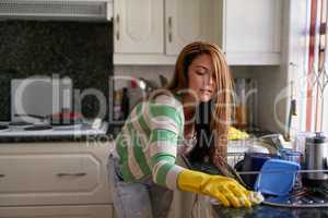 Shes a thorough cleaner. Shot of a young woman cleaning at home.