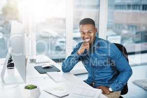Success tastes better when youve worked hard for it. Portrait of a young businessman posing and in good spirits at his office desk.