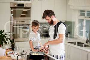 And thats the secret to fluffy scrambled eggs. Shot of an adorable little boy and his father making breakfast together at home.