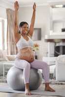 Stretching sure helps with pregnancy aches and pains. Shot of a beautiful young pregnant woman exercising at home.