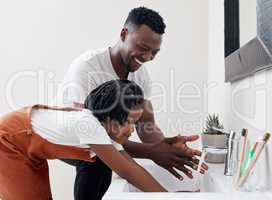 Time to wash all those germs off. Shot of a young father helping his daughter wash her hands in the bathroom at home.