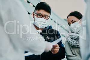 This permits us to travel. Shot of a young man talking to a healthcare worker in a hazmat suit during an outbreak.