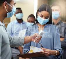 There you go. Cropped shot of an attractive young businesswoman wearing a mask and going through covid screen while standing at the head of a queue in her office.