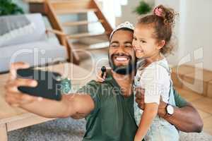 Shes my true princess. Shot of a father and his little daughter taking selfies while playing together at home.