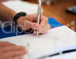 Hes diligent about his homework. Closeup shot of an unidentifiable man doing his homework at home.